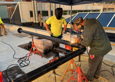 Crew Welding A Pipe